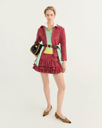 Model wearing a red skirt and red cardigan