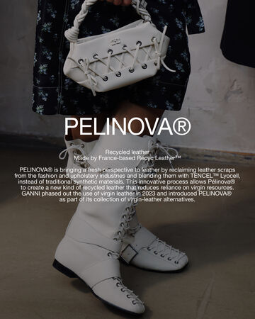 Front view of a persons legs wearing a white high boots and a matching white Bou Bag featuring circular white text overlay reading PELINOVA