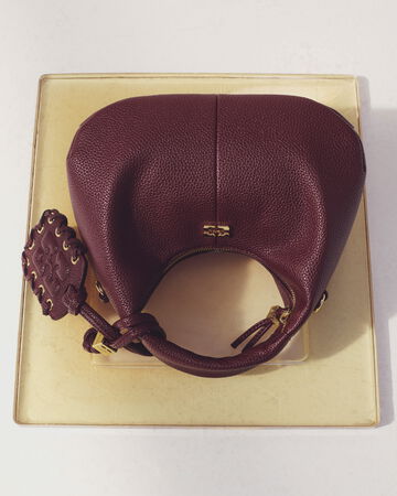 Brown Mini Hobo bag on a yellow tray on a table