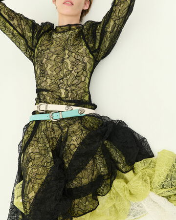 Model wearing a black and yellow lace dress with longe sleeves