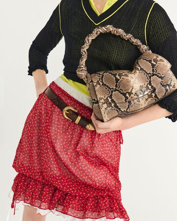 Model wearing a red patterned mini skirt and black shoulder bag
