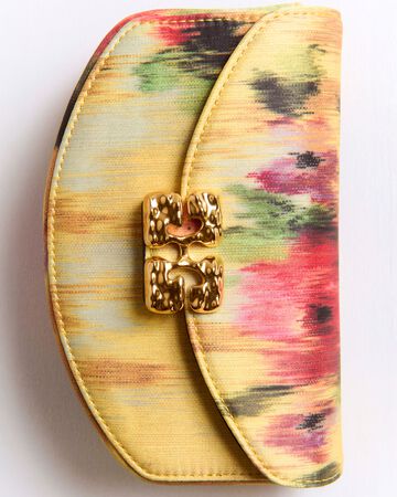 Close-up view of the GANNI bag featuring a colorful yellow, pink, and green abstract watercolor print fabric with a gold-tone butterfly logo clasp