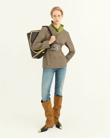 Model wearing a grey blazer and blue jeans holder a black shoulder bag