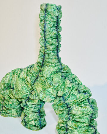 Jens Ole Árnason close-up: Detailed look at the overlapping textured green bio-material tiles covering the surface of the sculpture