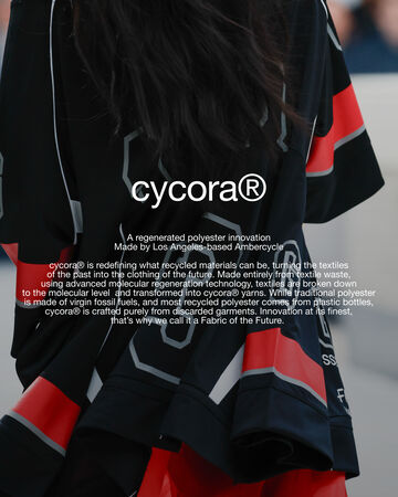 Back view of a person wearing a black football jersey featuring circular white text overlay reading cycora