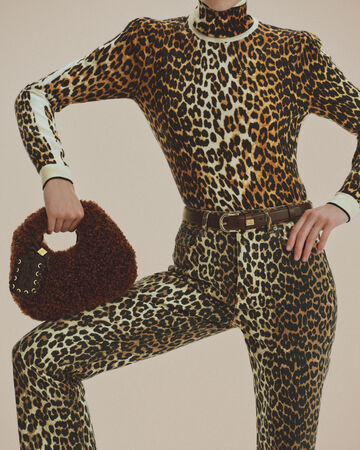 Model wearing leopard denim and holding GANNI Mini hobo bag