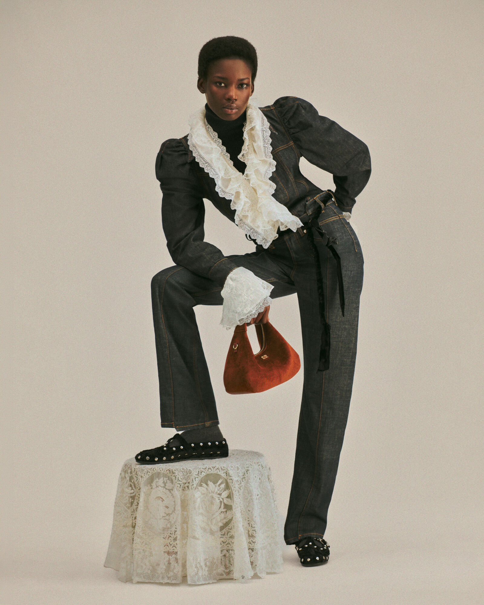 Dark denim GANNI suit with sculpted sleeves and white lace ruffles
