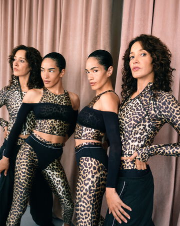 Models wearing GANNI x Lululemon leopard tops