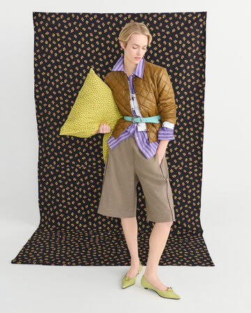 Model wearing a patterned short set in front of a backdrop