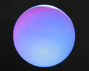 A smooth, minimalist view of a large circular sphere glowing with a soft purple and blue color gradient against a dark background