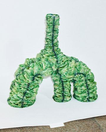 Jens Ole Árnason material installation: An abstract, three-legged organic sculpture crafted entirely from textured green plant-based tiles